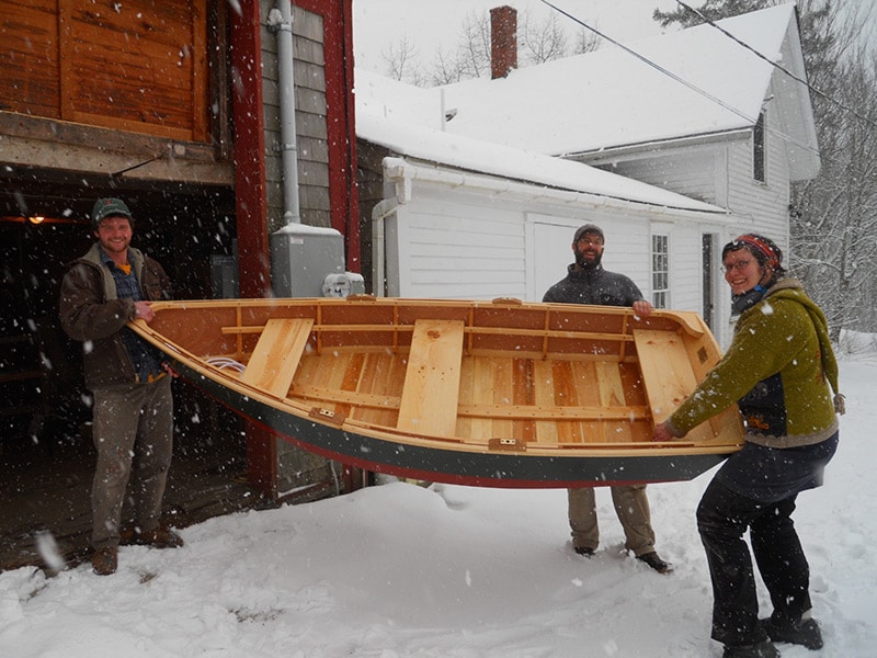 carrying a new skiff in the snow